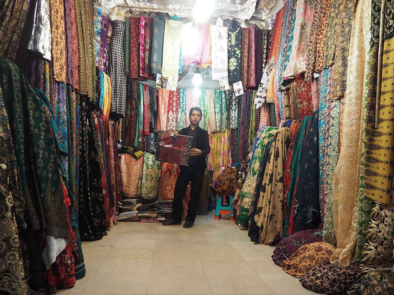 Interior do Grande Bazar de Kerman, com lojas vendendo tapetes e artesanatos locais.
