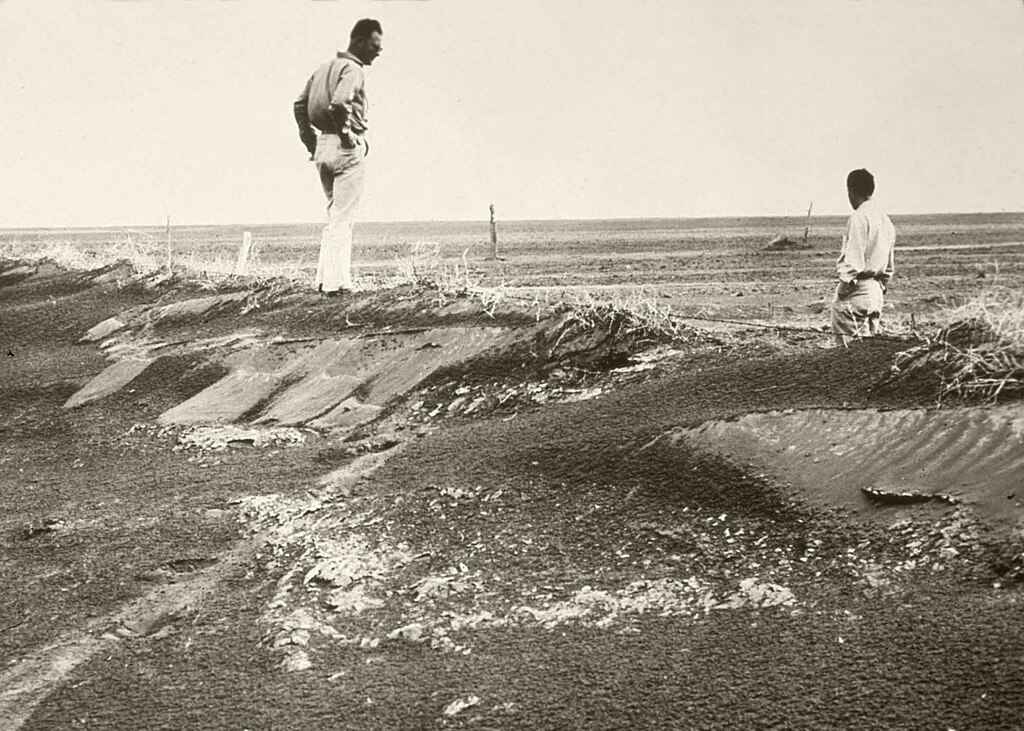 imagem de agricultores nos anos 1930 praticando técnicas de conservação do solo para prevenir a erosão e a poeira